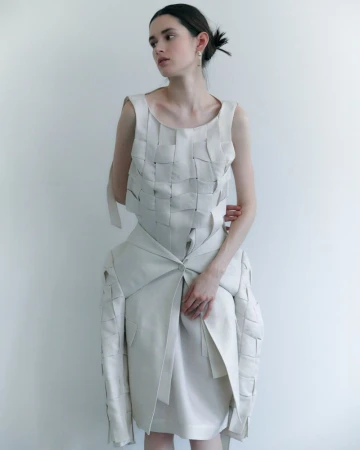 Model in woven cream dress against a bright white background for D'Scene Magazine style story