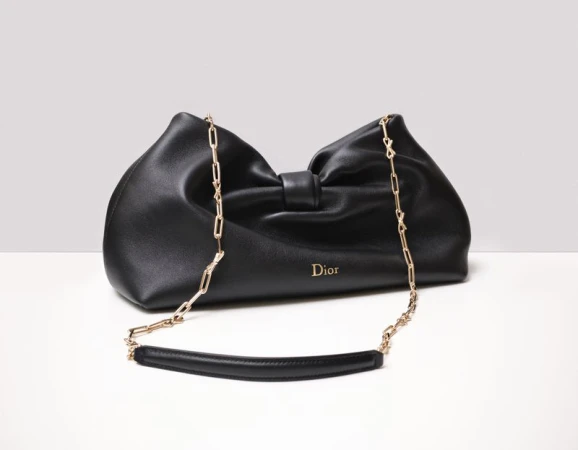 Black leather Dior handbag with gold chain strap displayed on a clean white studio surface.