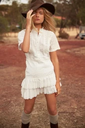 Model Charlie Newman wearing a white lace dress and brown hat for Sir The Label