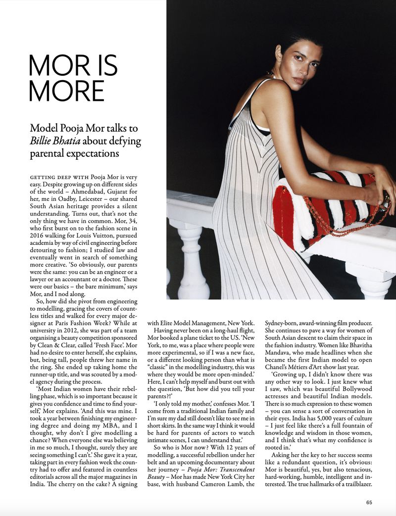 Model Pooja Mor leaning against a white balustrade holding a striped red bag for Grazia UK editorial spread