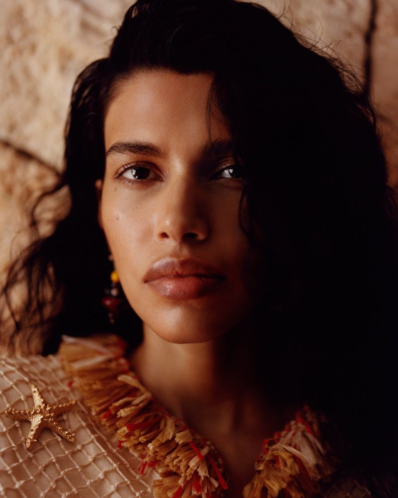 Close-up portrait of model Pooja Mor wearing a textured top with a gold starfish pin for Grazia UK Shore Things editorial.