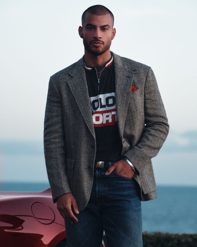 Man wearing a tweed blazer and polo sport shirt standing against an ocean and sky background