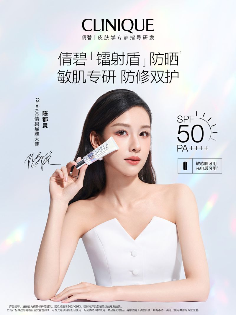 Woman in white strapless top holding Clinique sunscreen tube near her face against a bright studio background.