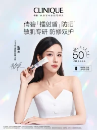 Woman in white strapless top holding Clinique sunscreen tube near her face against a bright studio background.