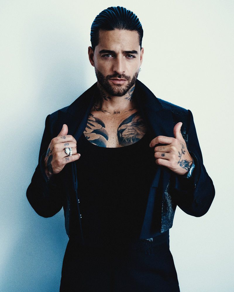 Portrait of Maluma wearing a black jacket and tank top against a plain light background for Juan Luis x MET Gala.