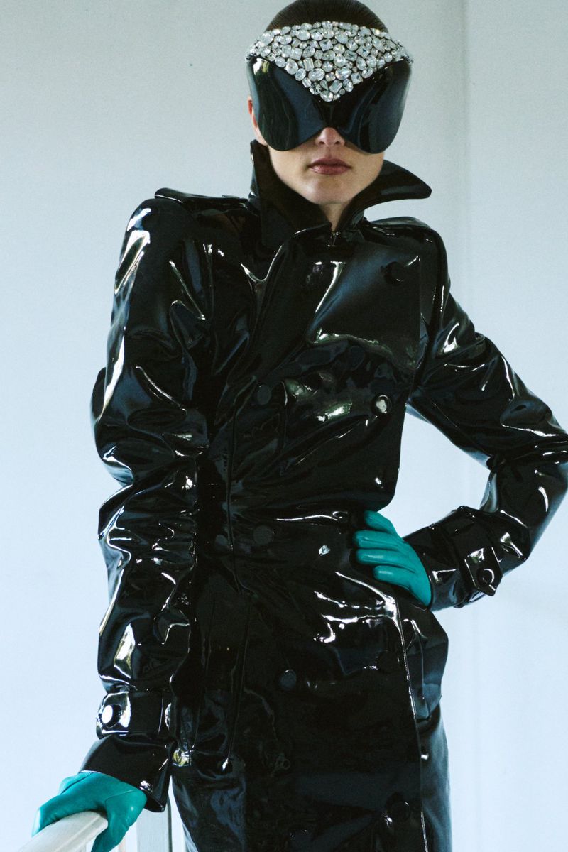 Model Gertrud Rose wearing a glossy black vinyl coat and crystal-embellished visor for Re-Edition Magazine