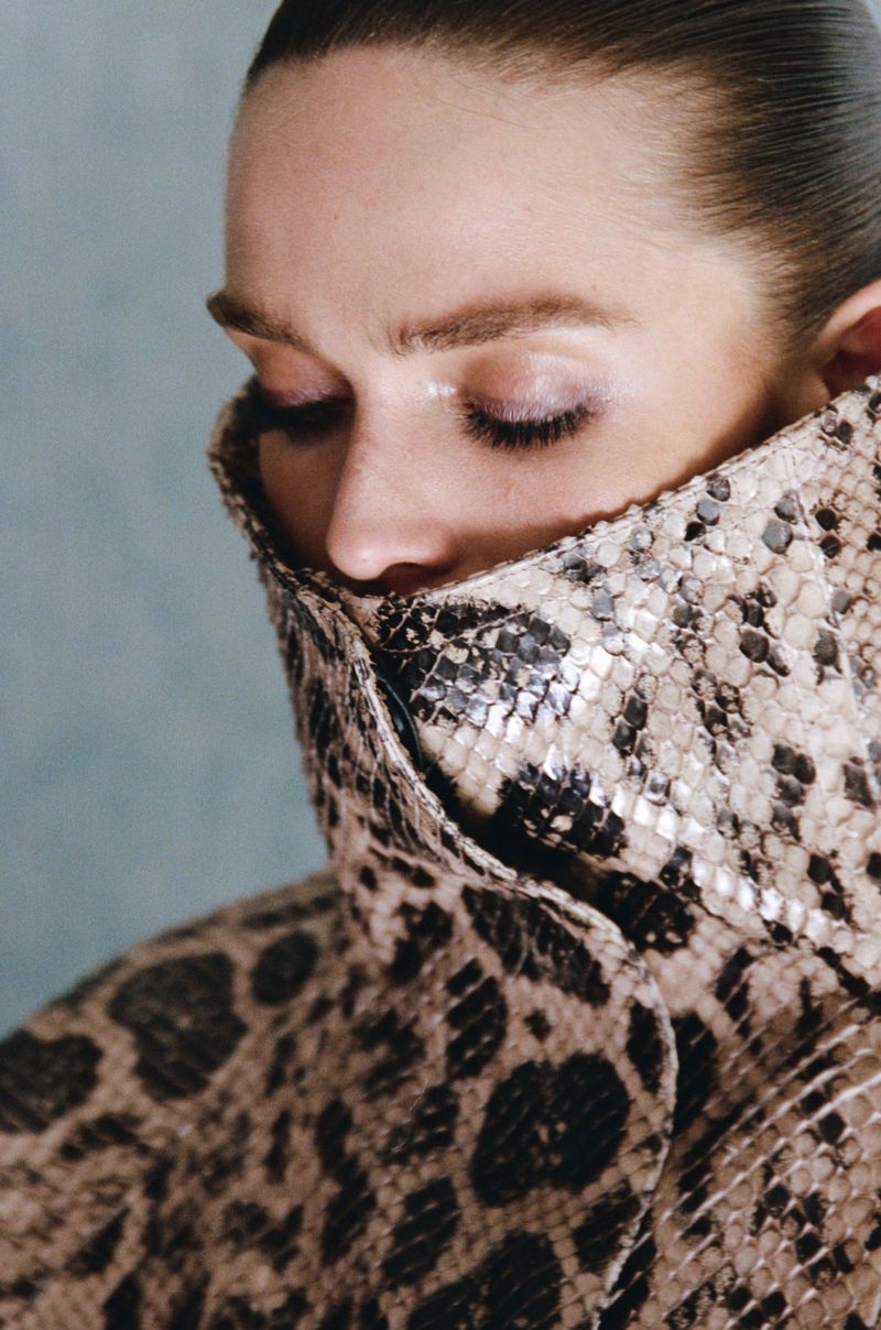 Model Gertrud Rose wearing a snakeskin print high-collar coat in a fashion editorial for Re-Edition Magazine