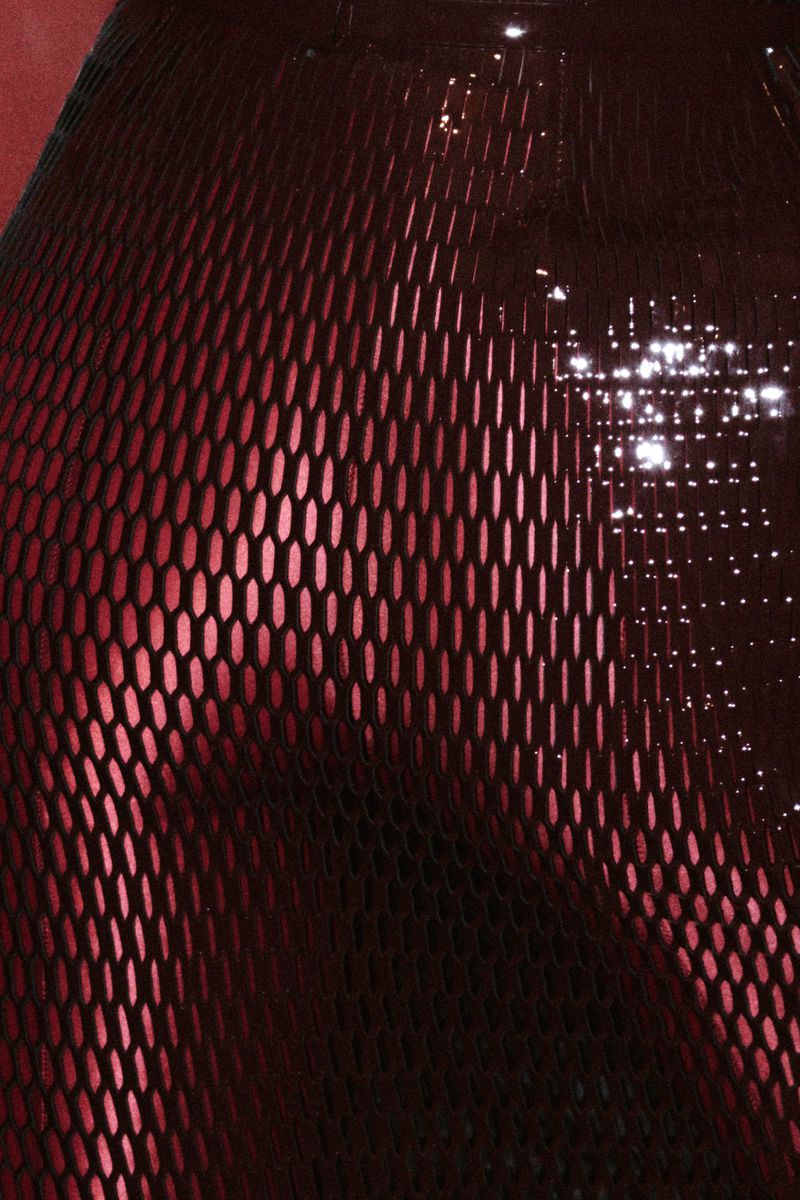 Macro view of dark metallic mesh textured fabric with red highlights for Re-Edition Magazine by Phil Engelhardt