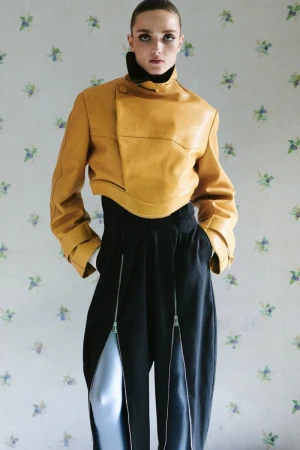 Model Gertrud Rose in a cropped yellow jacket and black trousers against floral wallpaper for Re-Edition Magazine