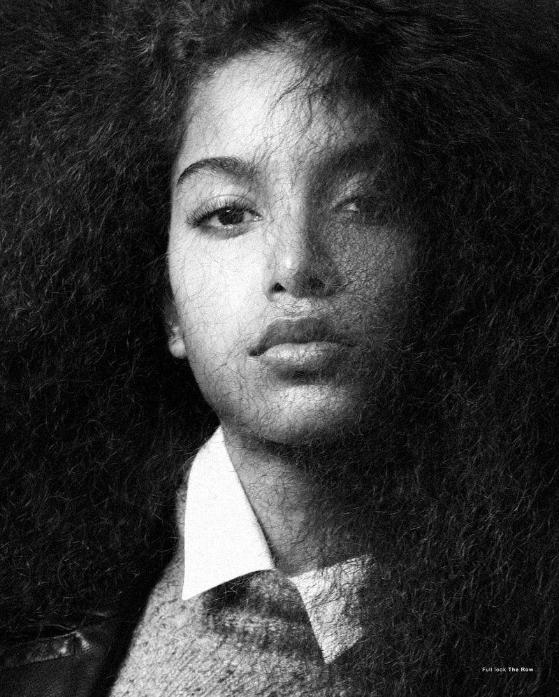 Close-up monochrome portrait of model Luna Yohannan with voluminous dark hair framing her face and a white collared shirt.