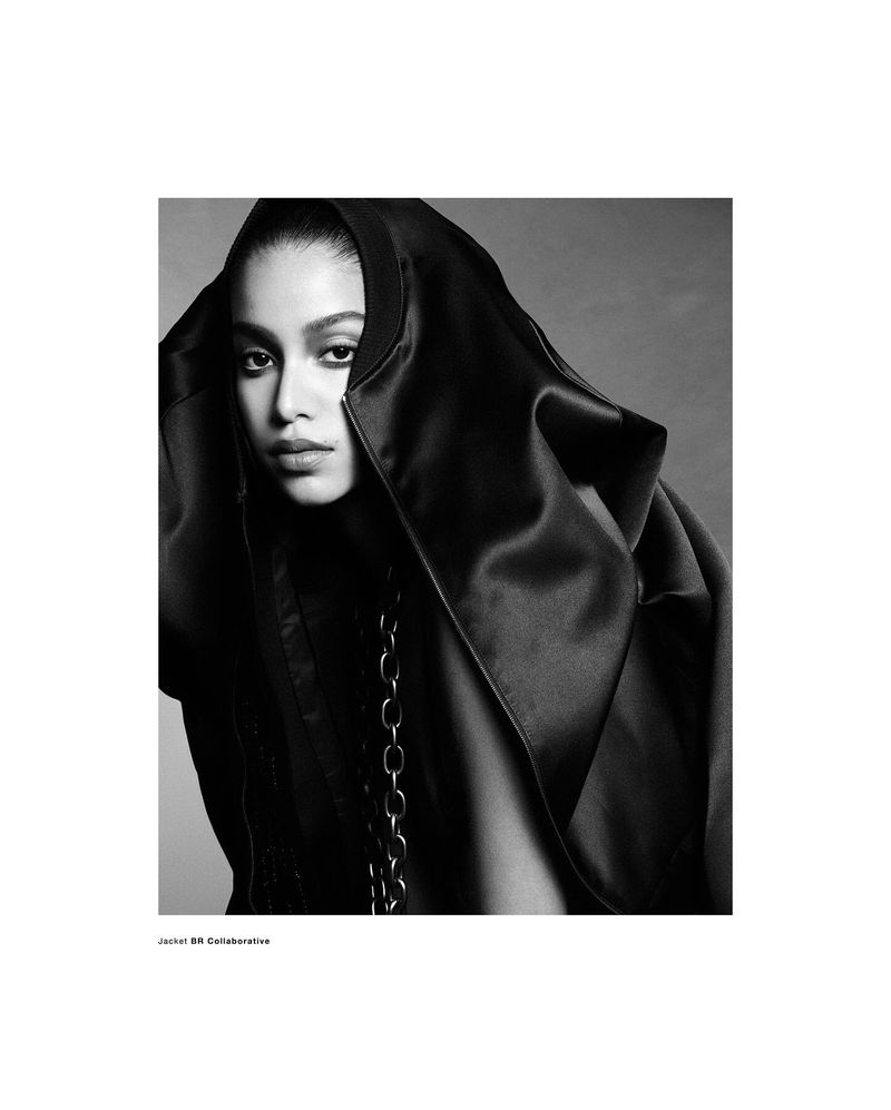 Model Luna Yohannan in a black hooded garment with a chain detail shot in monochrome for Double Vision