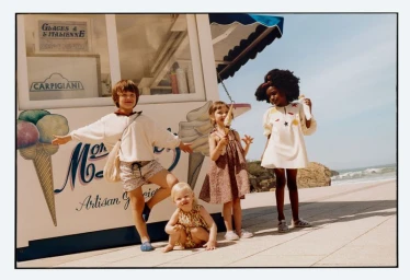 Children posing in front of an ice cream kiosk near the beach for Zara Summer Memories campaign photographed by Toby Coulson.