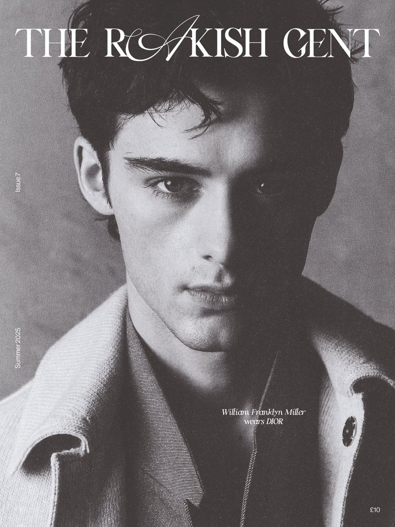 Monochromatic close-up of a young man wearing a buttoned shirt and jacket, posing on the cover of "The Rakish Gent" magazine.