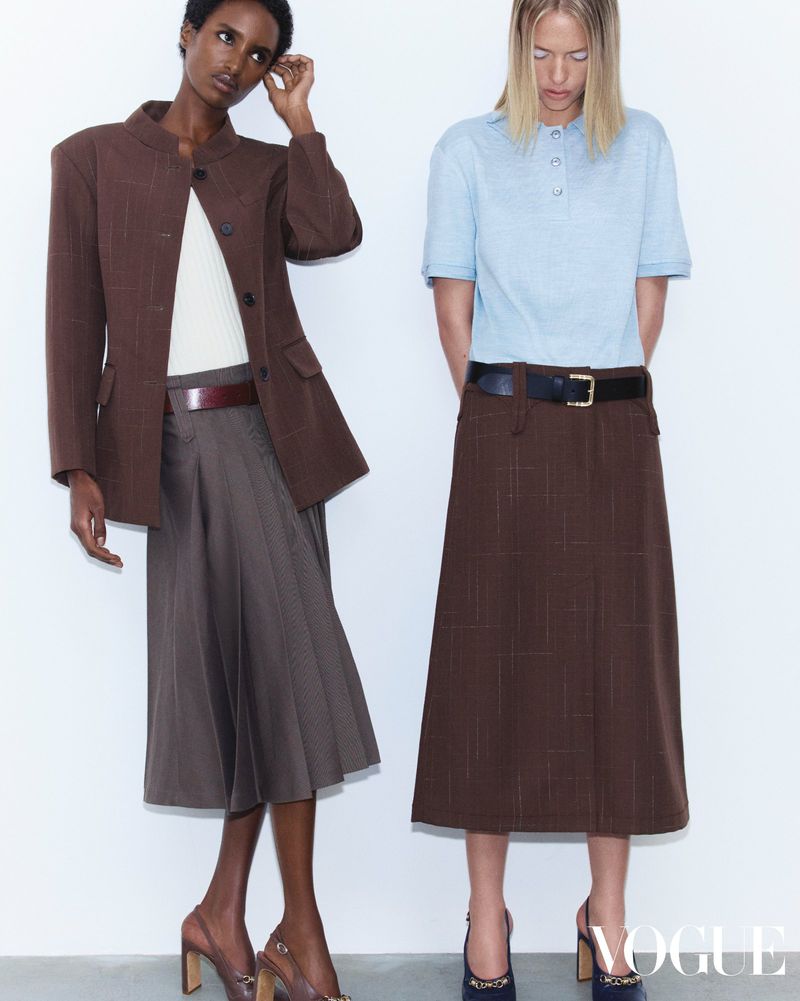 Two models posing against a white seamless background for Vogue Hong Kong editorial, wearing tailored skirts and jackets