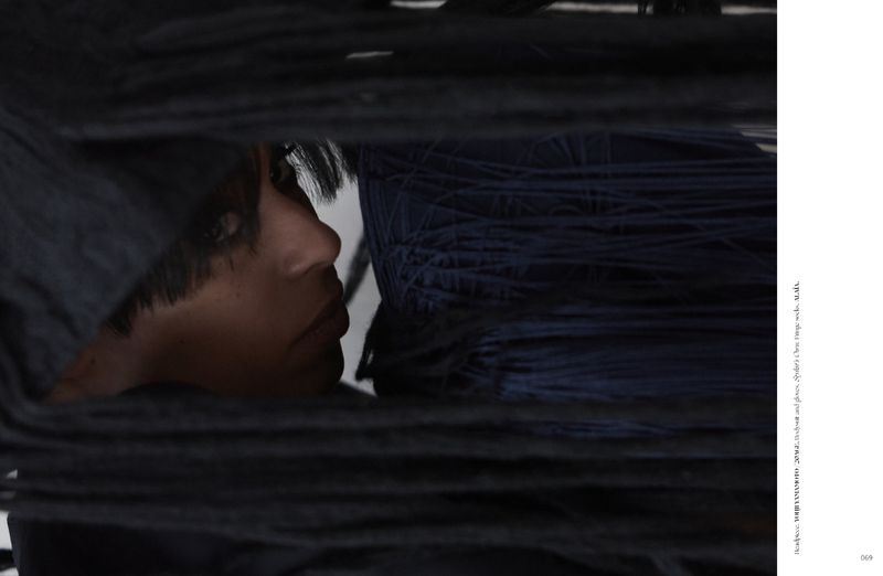 Close-up portrait of a woman framed behind layers of dark yarn or string for Dry Clean Only Magazine