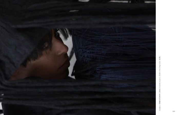 Close-up portrait of a woman framed behind layers of dark yarn or string for Dry Clean Only Magazine