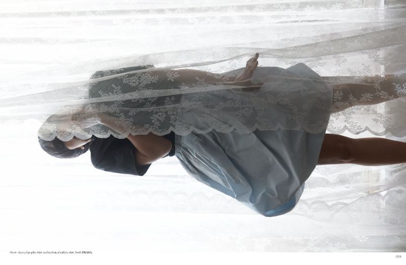 Model wearing a dark top and blue skirt behind sheer lace curtains for Dry Clean Only Magazine