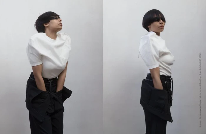 Model in white t-shirt and black trousers posing against a white background for Dry Clean Only Magazine