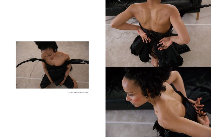 Model wearing a black feather corset dress in a high-angle editorial layout for Dry Clean Only Magazine shot by Jebi Labembika.