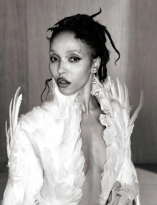 Portrait of FKA twigs wearing a white feathered garment in a 10 Magazine editorial photographed by Ib Kamara