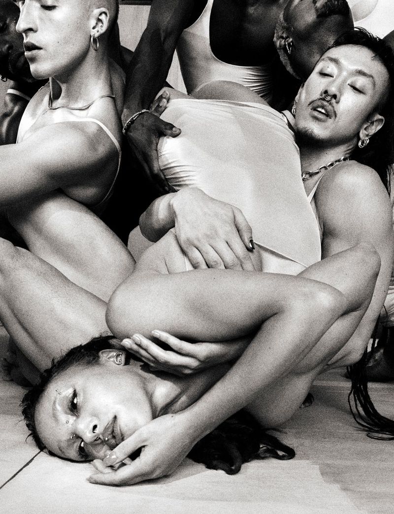 Black and white editorial portrait of a group of people intertwined in a dynamic sculptural pose for 10 Magazine