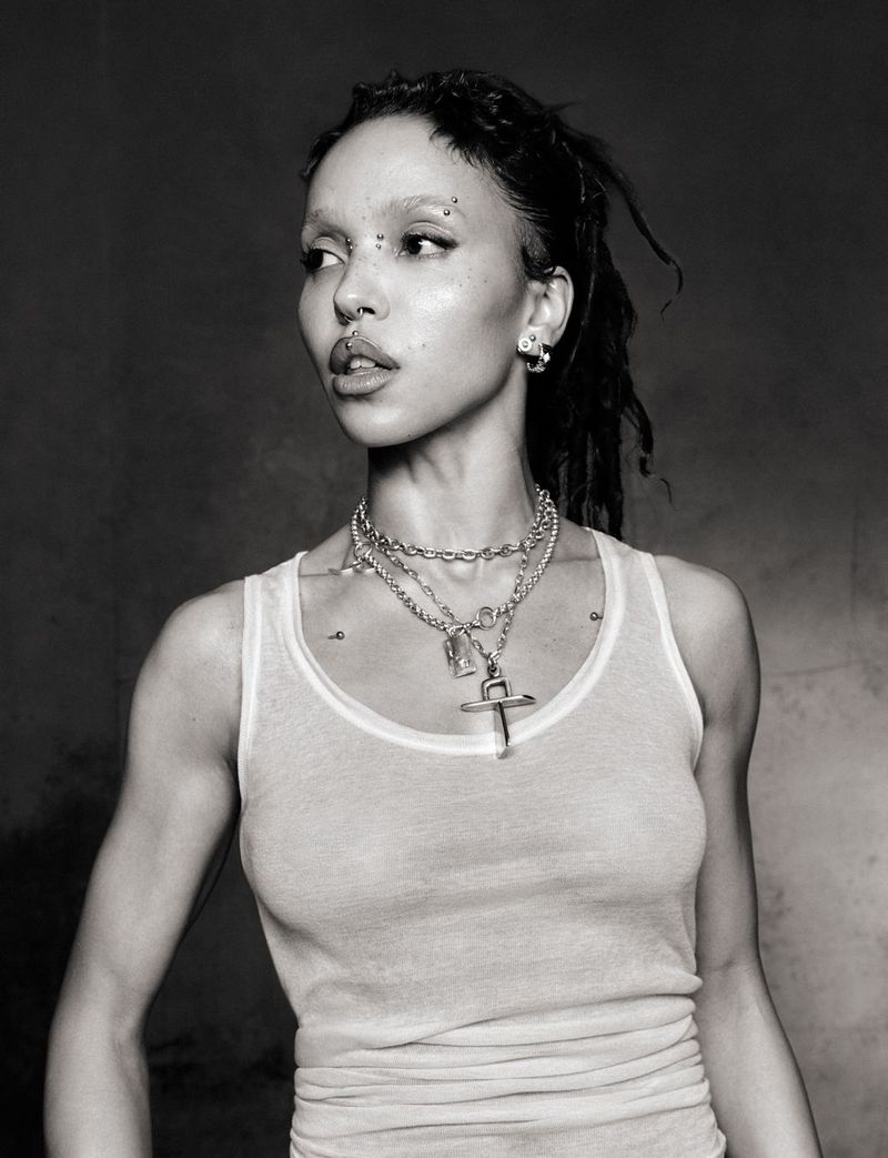 FKA twigs wearing a white tank top and layered silver chain necklaces in a black and white editorial portrait by Ib Kamara.