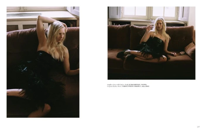 Model Vilma Friedlander lounging on a brown sofa in a black strapless dress for Dry Clean Only Magazine