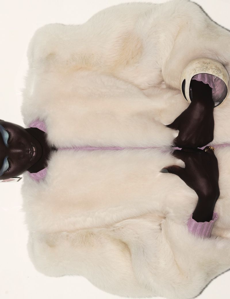 Model wearing a fuzzy white jacket against a neutral backdrop, photographed by Jean Marques for Dazed MENA.