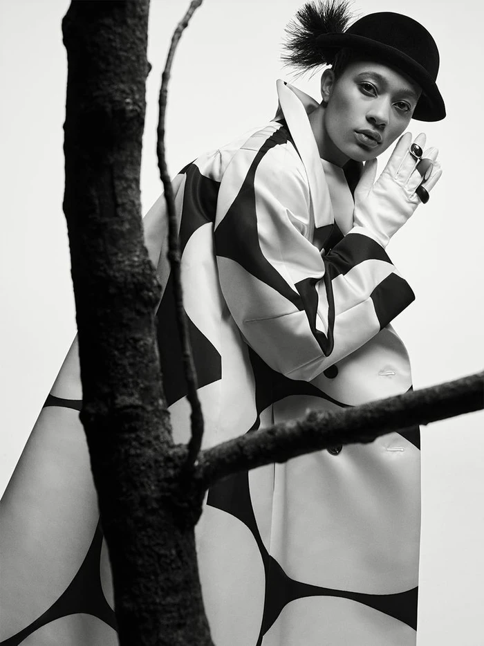 Model Selena Forrest wearing a patterned coat and bowler hat for D Repubblica photographed by Ethan James Green