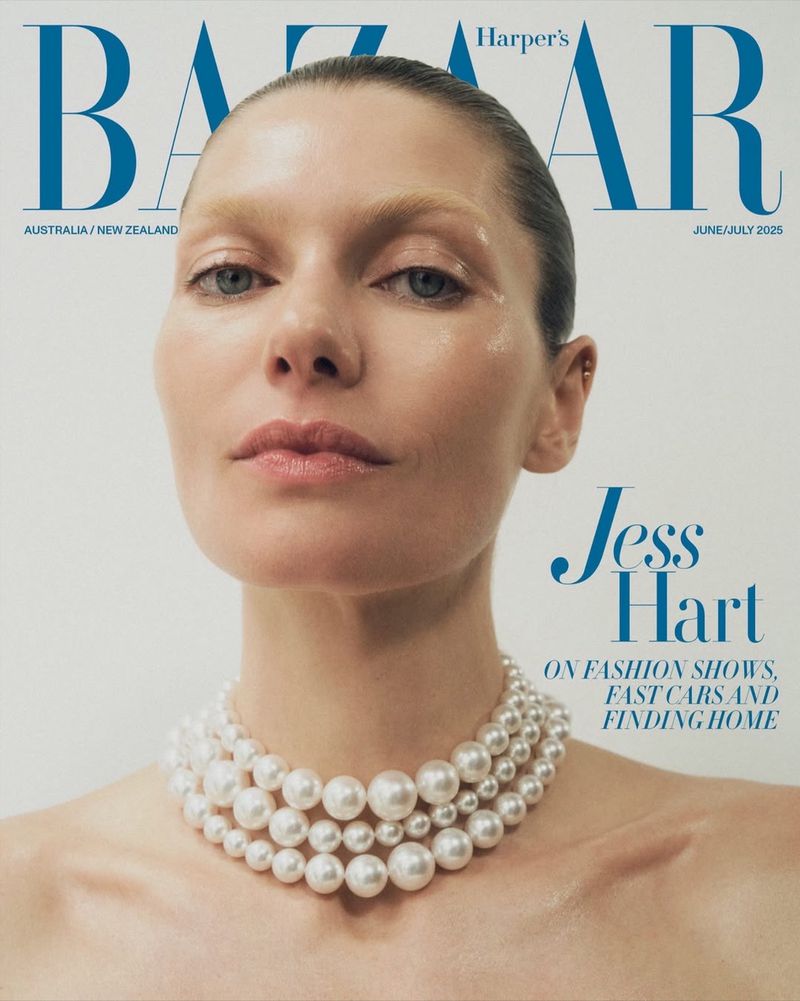 A fair-skinned woman with wet-look hair poses for a Harper's Bazaar cover, wearing a multi-strand pearl necklace against a white backdrop.