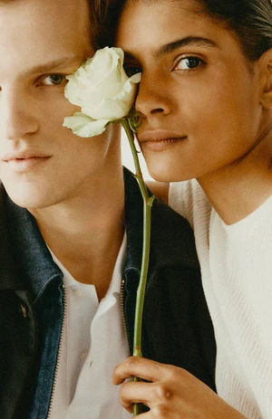 Close-up portrait of two models holding a white rose between them for Trussardi S/S 26