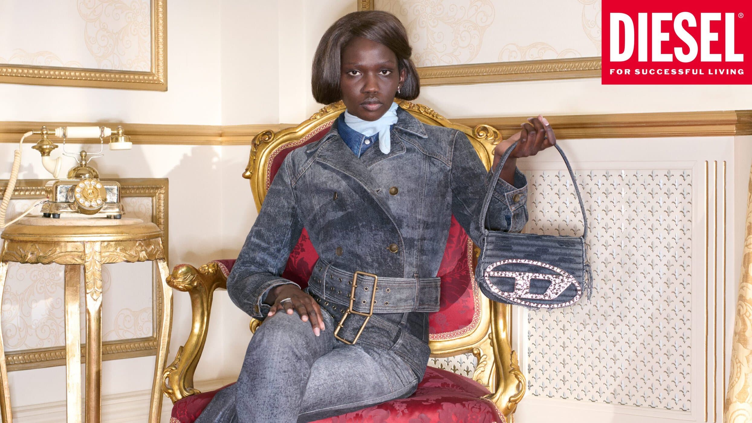 Model seated in an ornate gold armchair holding a denim handbag for Diesel 2026 ad campaign