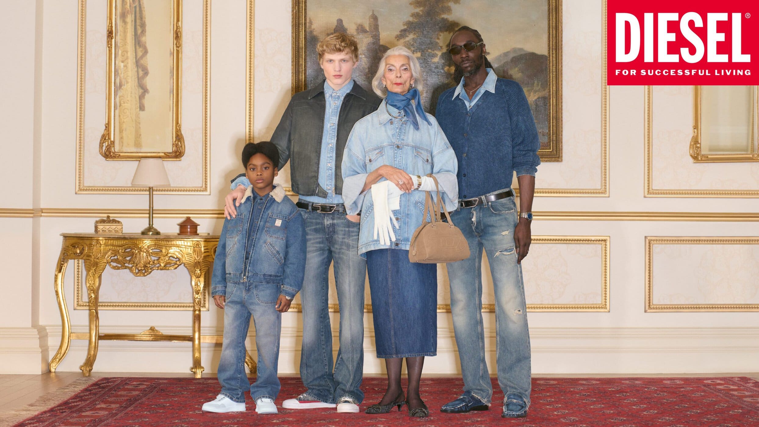Group of four diverse models in denim apparel standing together indoors before an ornate framed painting and classical molding walls.