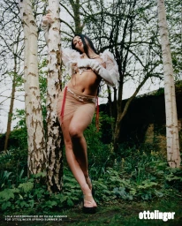 Model Lola Leon leaning against a birch tree in a woodland setting wearing sheer apparel for Ottolinger Spring 2026 ad campaign