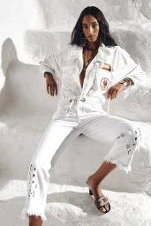 Model wearing a white outfit seated on white stone steps during the Isabel Marant Spring 2026 ad campaign.