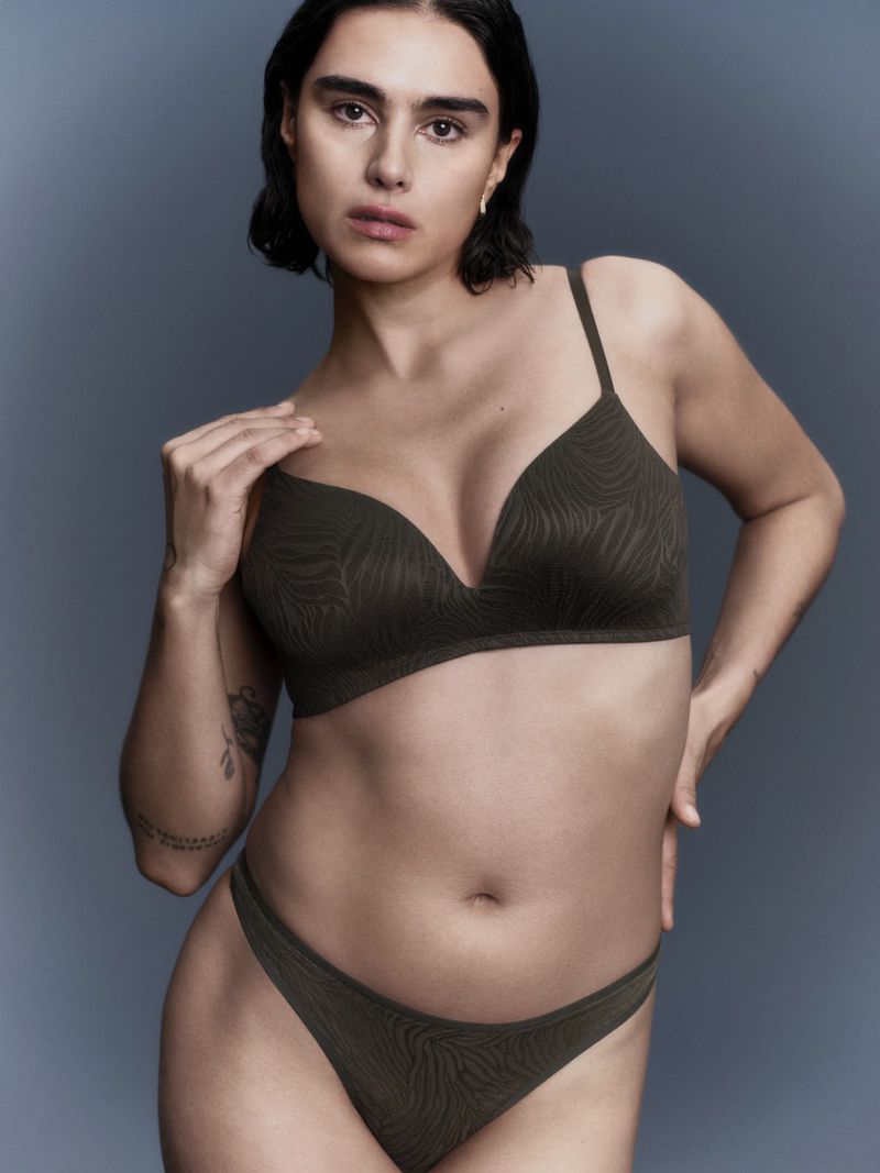 Model wearing a dark green patterned lingerie set against a soft grey studio background for Marks and Spencer