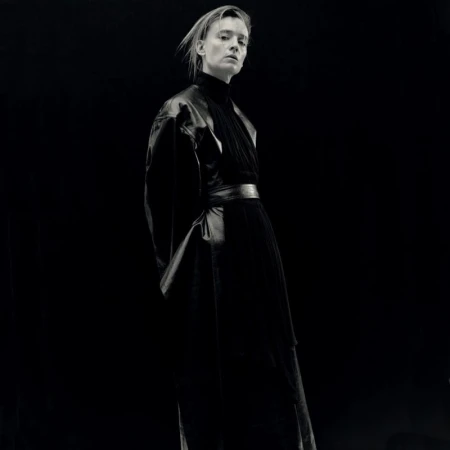 Monochrome portrait of a model wearing a dark leather coat against a black background shot by Kito Munoz for Re-Edition Magazine.
