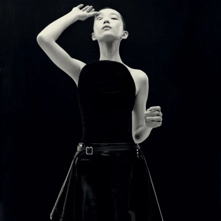 Model in black top and skirt posing against a dark background, captured by Kito Munoz for Re-Edition Magazine.