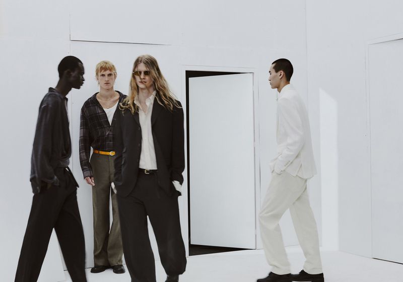 Four male models posing in contemporary menswear inside a minimalist white room for Zara evening edition campaign