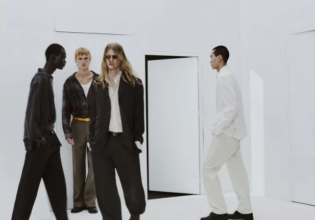 Four male models posing in contemporary menswear inside a minimalist white room for Zara evening edition campaign