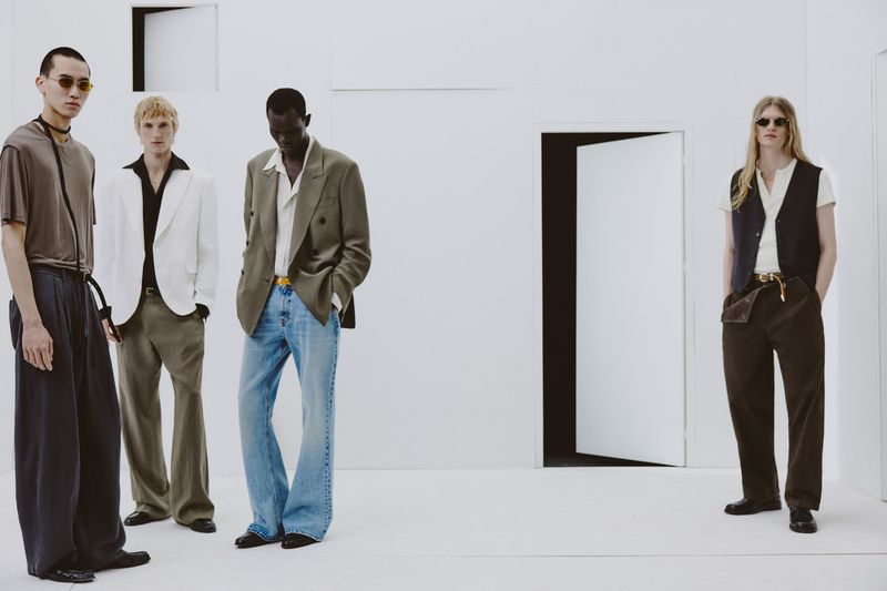 Four male models wearing contemporary Zara menswear against a minimalist white studio set with doors.