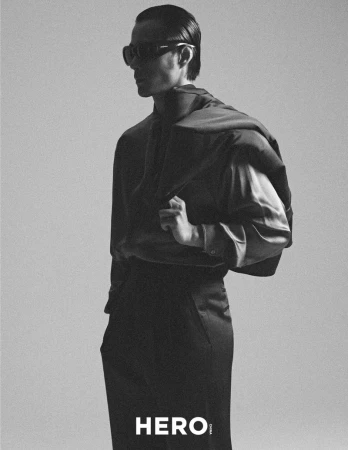 Monochrome fashion portrait of male model Zhao Lei wearing dark sunglasses and holding a jacket over his shoulder