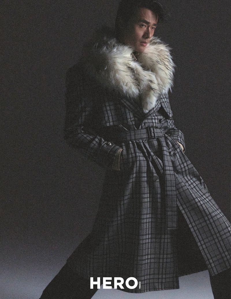 Model Zhao Lei wearing a belted plaid coat with a faux fur collar in a studio editorial for Hero China photographed by Shenyun Ren.