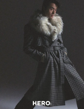 Model Zhao Lei wearing a belted plaid coat with a faux fur collar in a studio editorial for Hero China photographed by Shenyun Ren.