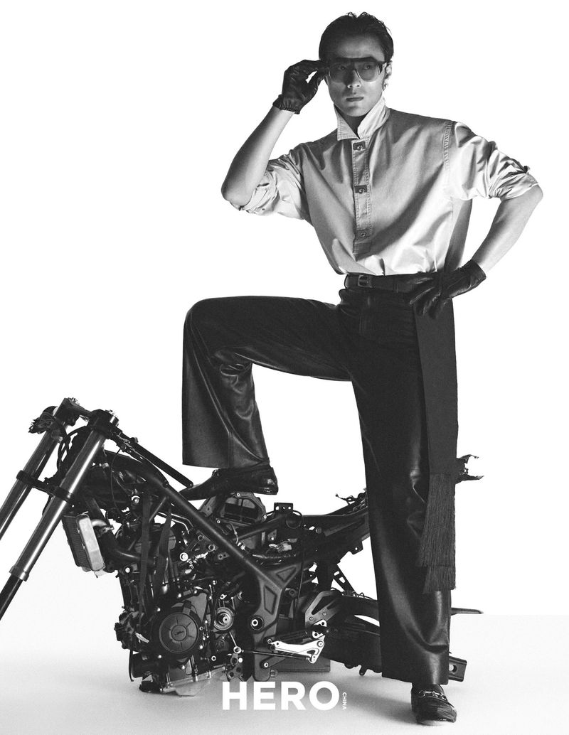 Model Zhao Lei posing with one foot on a stripped motorcycle frame wearing dark leather gloves and trousers for Hero China