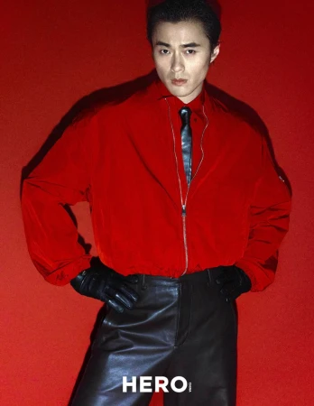 Model Zhao Lei wearing a red jacket and black leather trousers against a solid red background for Hero China.