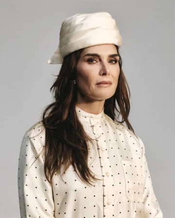 Brooke Shields wearing a cream patterned shirt and matching turban against a neutral backdrop for ODDA Magazine editorial