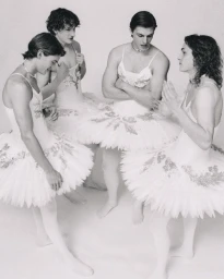 Four male dancers wearing white tutus and tights posed together in a studio setting for ODDA Magazine