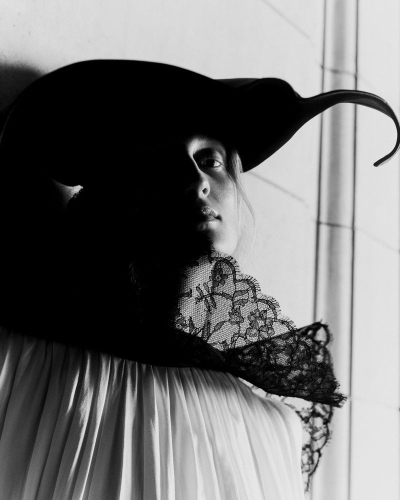 Model wearing a wide-brimmed black hat and lace collar for Telegraph Luxury shot by Daniel Benson