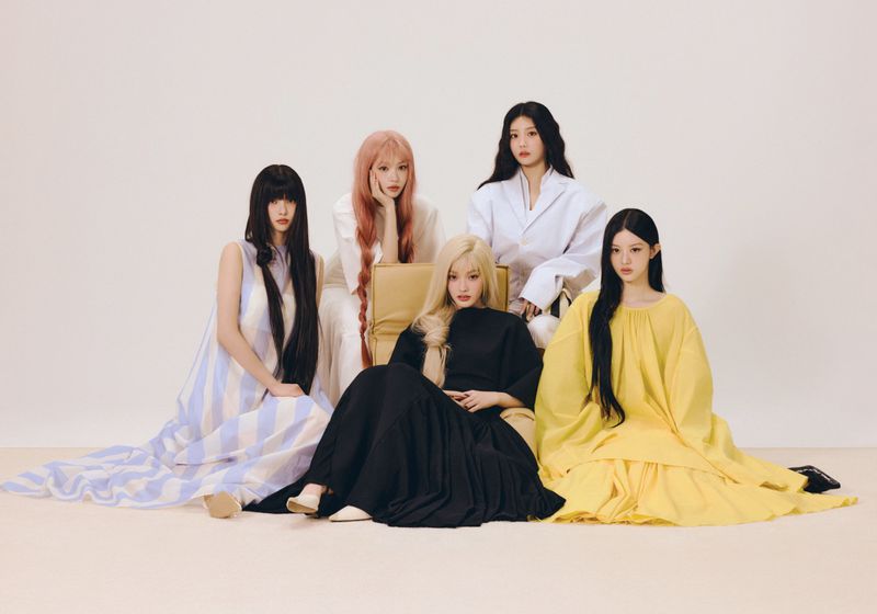 Five female models posing together in colorful flowing dresses against a plain light background for ODDA Magazine.